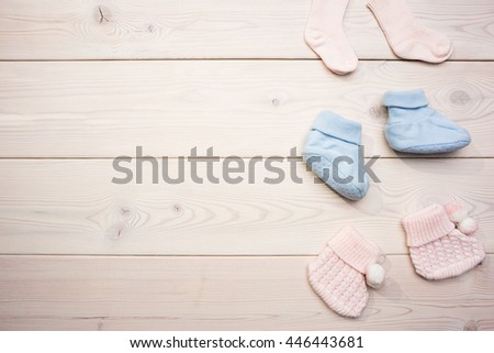Cute baby girl and baby boy socks on blank wooden surface. Mock up