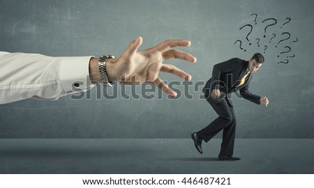 Businessman with question marks running away from a big hand concept on background