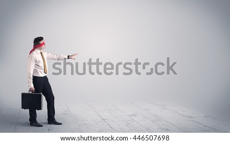 A young male business person in elegant dress standing with red blindfolds in a clear, empty space concept.