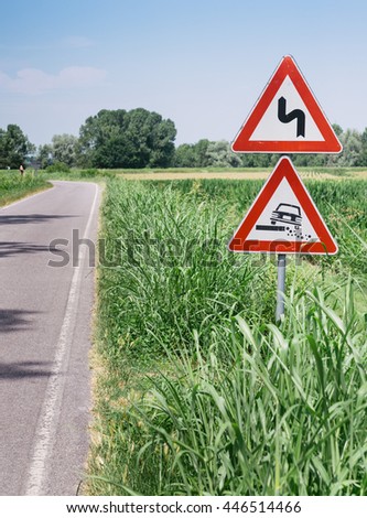 Hazardous Shoulder European road sign along dirt road in Italian countryside on sky background