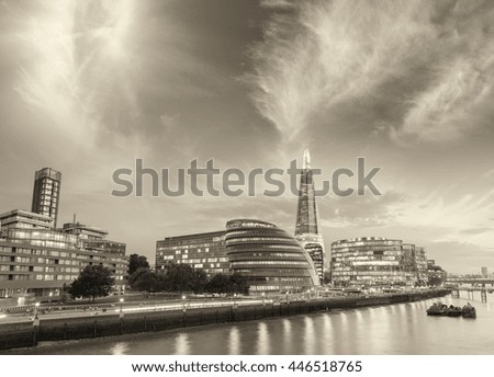 London, UK. City buildings along Thames river at dusk.