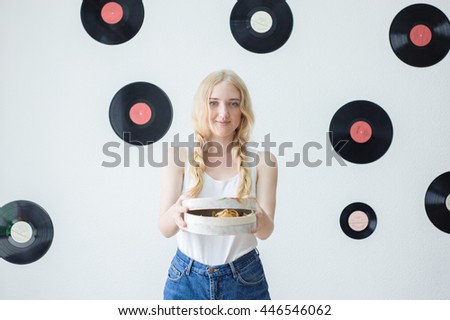 portrait of a beautiful young girl in a white T-shirt with a gift on a white background
