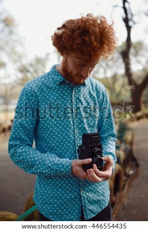 The red-haired guy holding a medium format film camera in his hands