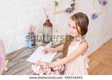 Little girl writer with a pen feather in hand