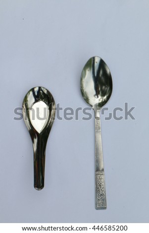 Tablespoon and teaspoon on white background