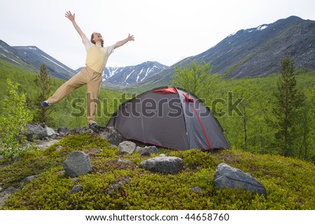 Tourist enjoying lovely morning near his tent at mountains
