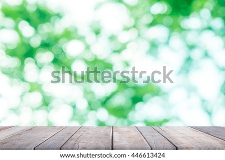 Empty of wood table top on blur of fresh green abstract background - For montage product display or design key visual layout