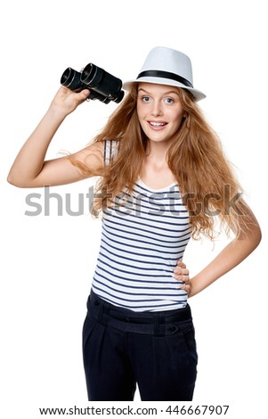 Young beautiful teen female in striped tee and white straw fedora hat holding binoculars and looking at camera smiling happy, over white background