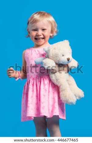 Portrait of beautiful young girl in pink dress against blue background