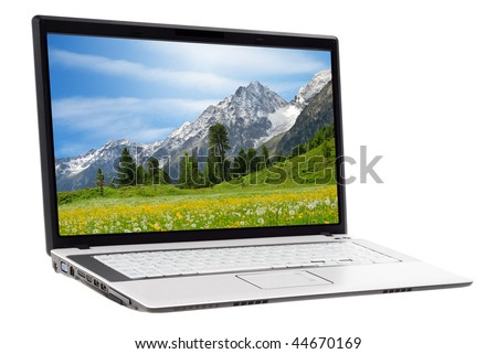 White laptop displaying a beautiful landscape of a meadow and mountains in spring