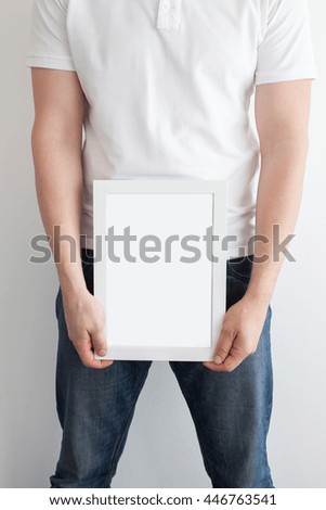 Hands of the man hold a frame with a clean sheet. White frame with a clean sheet on a white background.
