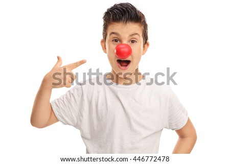 Excited kid pointing to a red clown nose on his face isolated on white background