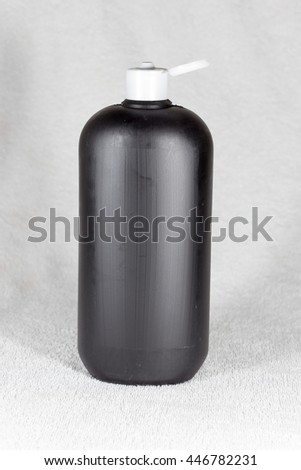 Black bottle of shampoo on a white background
