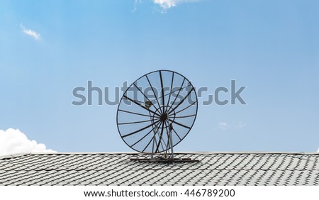 Satellite dish on roof top against cloudy sky