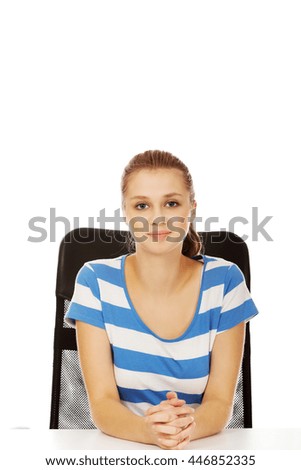 Smile teenage woman sitting at the desk