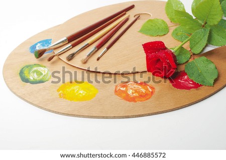 Artist palette, artist brushes and red rose