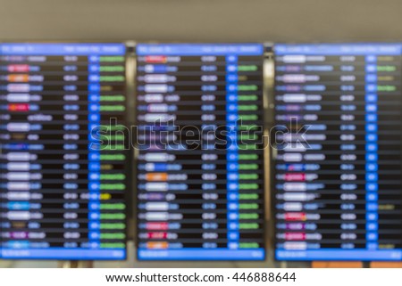 blurred image flights information board in airport terminal.