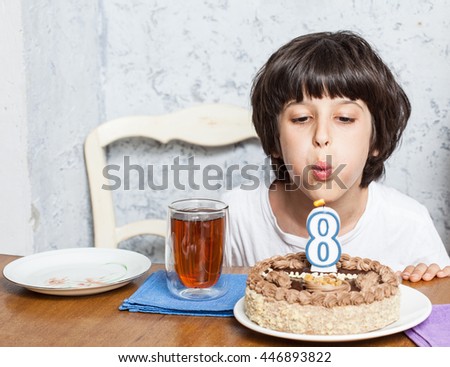 boy blowing out candles on birthday cake. digital eight. eight birthday. celebration