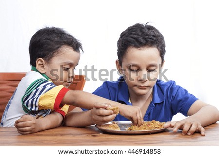 Two brothers sharing their food on wooden table