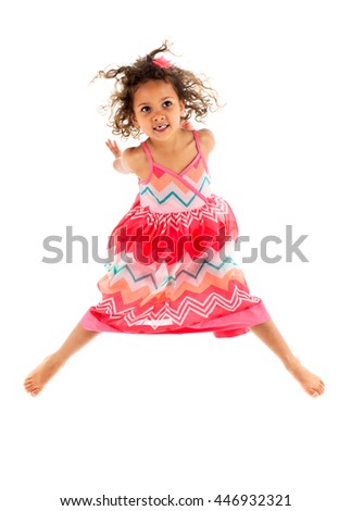 Little girl in orange pink dress and skirt is jumping in the air, celebrating being active. Successful, healthy childhood and adoption commercial.  Isolated on white background.