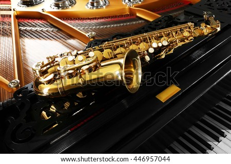 Saxophone lying on the piano, close up