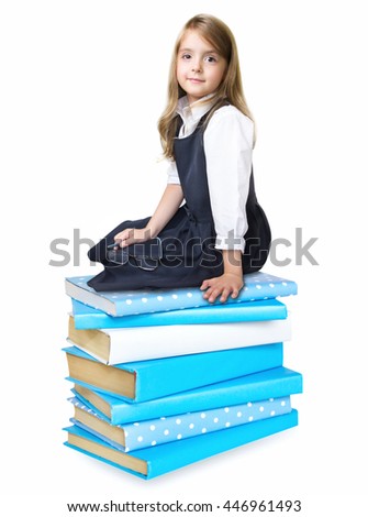 Child girl over stack of books isolated on white.. Schoolgirl sitting on pile of books. Elementary education concept.Back to school icon.Kid's literature.