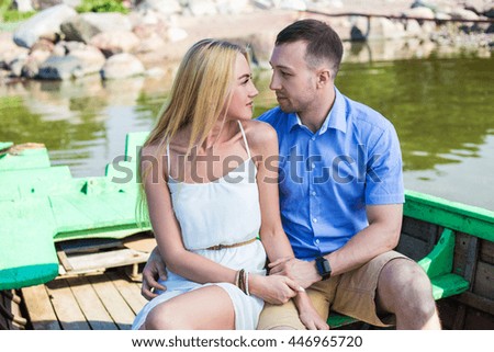 young beautiful couple in love sitting in old boat
