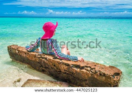 girl in pink hat on the kitchen couch in the ocean