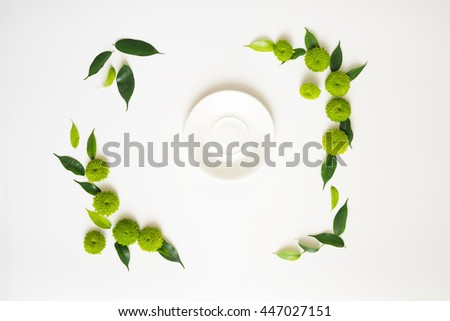 Plate with decoration of chrysanthemum flowers and ficus leaves isolated on white background. Overhead view. Flat lay. Royalty-Free Stock Photo #447027151
