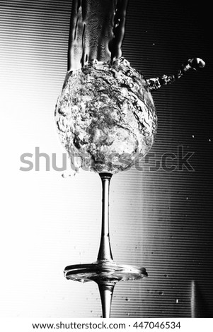 Water splashing in a wineglass in black and white color