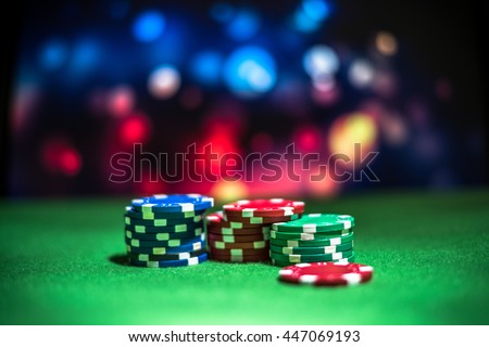 Blur background and chips, Stack of poker chips on a green table. Poker game theme Royalty-Free Stock Photo #447069193