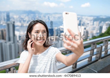Woman taking selfie by mobile phone in Hong Kong