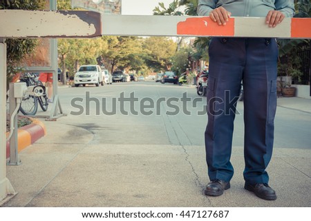 Security guard with barrier gate for access control at gateway , process in vintage style