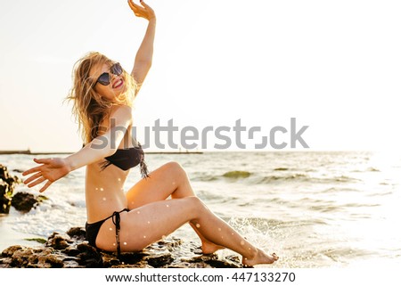 young beautiful female on beach enjoying vacation during sunset or sunrise