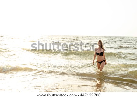 young beautiful female on beach enjoying vacation during sunset or sunrise