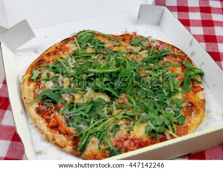 Vegetarian Pizza with rocket and tomatoes in a pizza box