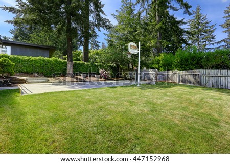 Basketball court with concrete floor and old wooden fence