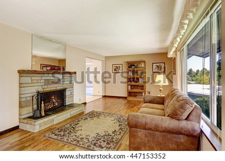 Old American house large living room interior with hardwood floor, rug and fireplace. 