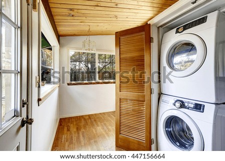 Laundry room with hardwood floor and view to fenced back yard