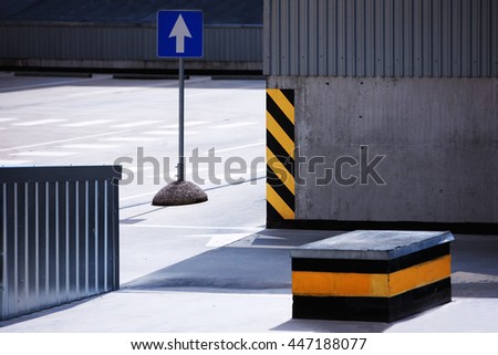Traffic sign on an empty parking with a striped orange paint with a warning about the dangers