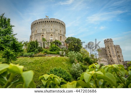 Windsor Castle with a blue sky background. The picture focuses on the Round Tower surrounded by the Moat garden. Windsor Castle is a royal residence at Windsor in the English county of Berkshire.