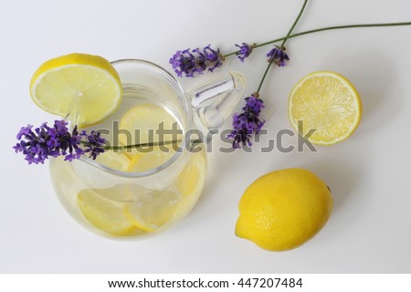 Summer lemonade in a glass jar with slices decorated with whole lemon and fresh lavender flower. Top view. Photo from above. 