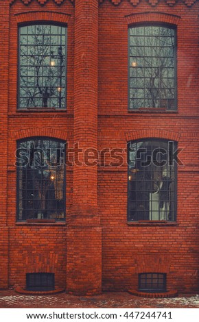 Brick wall factory wall with rounded window pattern.