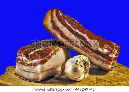 Domestic bacon and garlic on wooden kitchen board.                              
