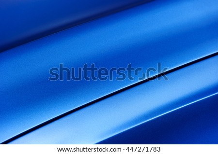 Surface of blue sport sedan car metal hood, part of vehicle bodywork, steel gradient line pattern, selective focus  Royalty-Free Stock Photo #447271783