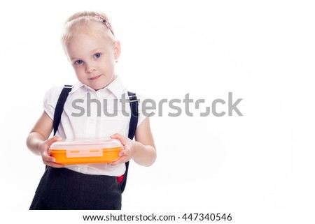 Little preschool girl hold lunch box in the hands, preparing for the school, isolated on white background. Royalty-Free Stock Photo #447340546