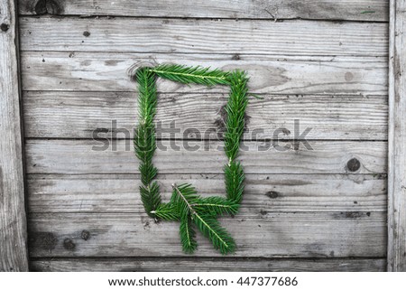 Letter  Q from fir tree branches on aged wooden boards