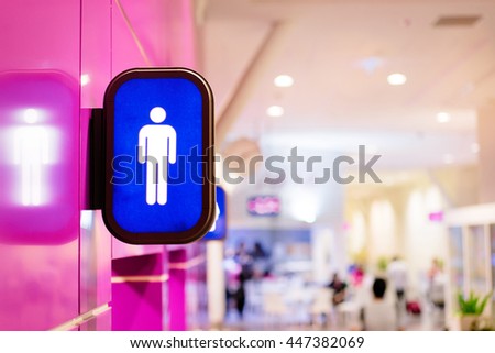 Toilets icon. Blue public restroom signs with a male symbol. Interior of airport terminal.