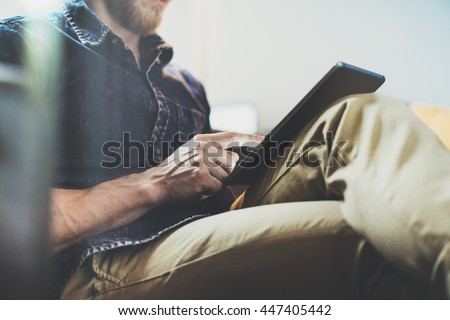 Bank account manager reading business news modern Interior Design Loft Office.Man relax Vintage Sofa,Use contemporary tablet,share information.Blurred Background.New Startup Idea Process.Closeup Royalty-Free Stock Photo #447405442