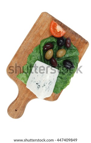 roquefort cheese on wooden platter with olives and tomato isolated over white background